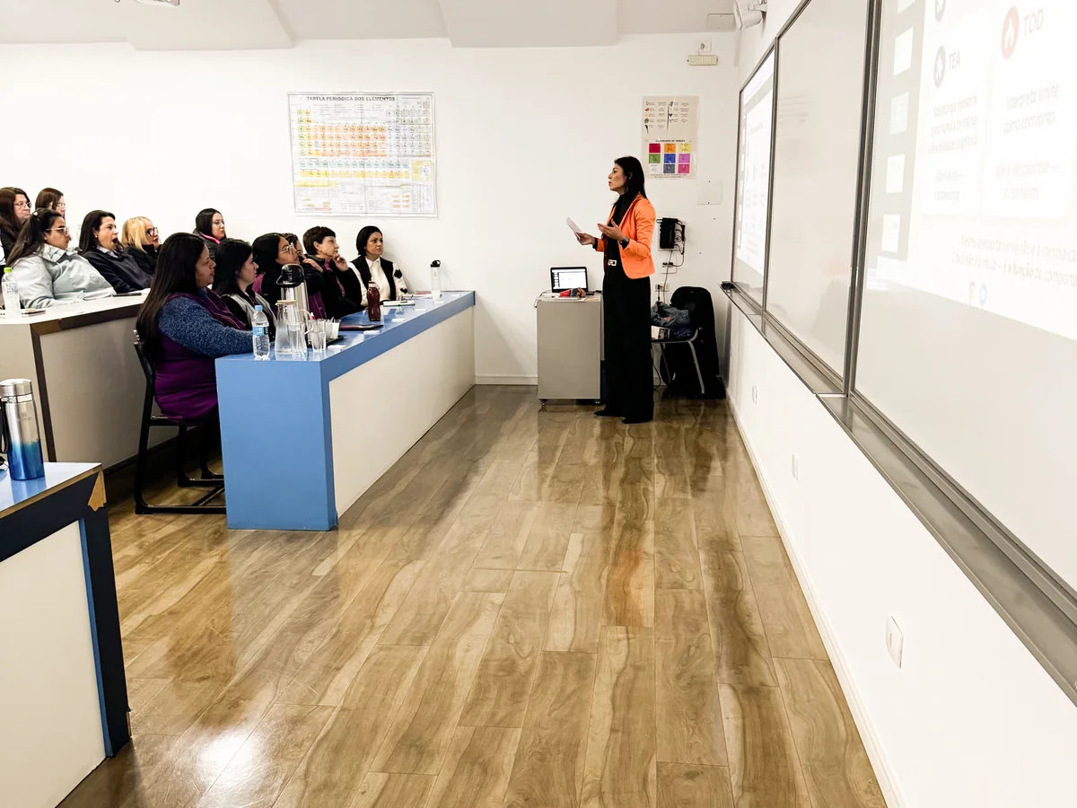 Vanessa Castro conversa com profissionais em uma sala preparada para formação